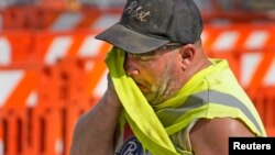 Jeff Nerby, with Arrow-Crete Construction, wipes away the sweat on a hot and humid day in Milwaukee, Wisconsin, June 17, 2024. (Mike De Sisti/The Milwaukee Journal Sentinel/USA Today Network via Reuters)