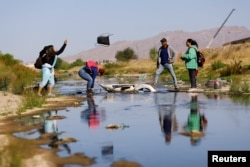 Migrants cross the Rio Bravo river with the intention of turning themselves in to the U.S. Border Patrol agents, as seen from Ciudad Juarez, Mexico, April 25, 2023.