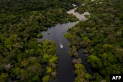 Sebuah perahu tampak menyusuri Sungai Jurura di jantung Hutan Amazon, Brazil, 15 Maret 2020. (Foto: AFP)