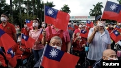 资料照：台湾老兵之家的老兵和护工挥舞台湾旗帜庆祝双十节。（2023年10月10日）