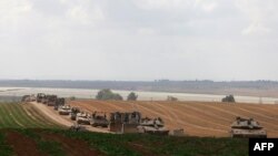 Israeli military vehicles roll near the border with the Gaza Strip on May 12, 2024.