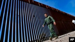 FILE - A Border Patrol deputy chief, Justin De La Torre, walks along the fence of the U.S.-Mexico border on Aug. 29, 2023, near Lukeville, Arizona. U.S. officials said on Oct. 25 that they have seen no indication of Hamas-directed foreign fighters trying to sneak into the U.S.