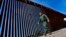FILE - A Border Patrol deputy chief, Justin De La Torre, walks along the fence of the U.S.-Mexico border on Aug. 29, 2023, near Lukeville, Arizona. U.S. officials said on Oct. 25 that they have seen no indication of Hamas-directed foreign fighters trying to sneak into the U.S.