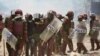 FILE - Riot police officers detain a supporter of Kenya's opposition leader Raila Odinga as they participate in a nationwide protest, in Mathare settlement of Nairobi, March 30, 2023.