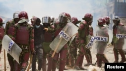 FILE - Riot police officers detain a supporter of Kenya's opposition leader Raila Odinga as they participate in a nationwide protest, in Mathare settlement of Nairobi, March 30, 2023.