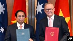 Australian Prime Minister Anthony Albanese and Vietnamese Prime Minister Pham Minh Chinh exchange documents during a signing ceremony at Parliament House in Canberra, Australia, March 7, 2024.