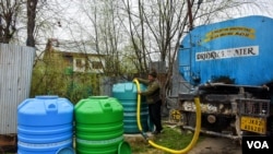 Imtiyaz Ahmad, a water tanker operator in Srinagar, fills water tanks in the early morning during Ramadan in the interiors of Dal Lake. (Muzamil Mattoo/VOA)