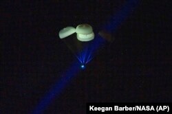 The capsule of the SpaceX Dragon Endurance spacecraft, slowed by parachutes, approaches the Gulf of Mexico as it returns to Earth with four astronauts, March 11, 2023.