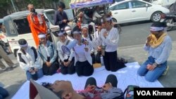 យុវជននាំគ្នាសម្តែងត្រាប់តាមលោក ឈុត វុទ្ធី អ្នកការពារព្រៃឈើ ដែលបានស្លាប់កាលពី១២ឆ្នាំមុន នាថ្ងៃទី២៦ ខែមេសា ឆ្នាំ២០២៤។ (មាស ដា/វីអូអេ)