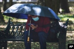 A person shades himself on a hot, sunny day in Chapultepec Park in Mexico City, June 13, 2023.