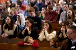Umat Katolik mengikuti misa di Benedictine College di Atchison, Kansas, Minggu, 3 Desember 2023. (AP/Charlie Riedel)