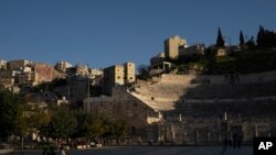 FILE - People walk at the site of the ancient Roman Theater, in Amman, Jordan, March 13, 2024.