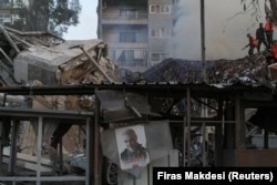 Foto mendiang komandan militer senior Iran, Jenderal Qassem Soleimani, terpampang di antara puing-puing di konsulat Iran di ibu kota Suriah, Damaskus, 1 April 2024. (Foto: REUTERS/Firas Makdesi)