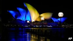 The sails of the Opera House are illuminated with the colors of Ukraine's national flag in solidarity with the country's people and government as the country is being invaded by Russia in Sydney, Australia, Feb. 28, 2022.