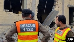 Rescuers stand at the site of an attack after militants rammed an explosive-laden vehicle into a Pakistan military base, in the town of Daraban of Dera Ismail Khan district, in Khyber Pakhtunkhwa province, on Dec. 12, 2023.