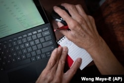 Alex Morisey calculates his finances and how much he would have left if he were to buy himself a pair of pants, Wednesday, Feb. 15, 2023, at a nursing home in Philadelphia. (AP Photo/Wong Maye-E)