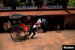 Trainee Yumeka Sakurai, 20, pulls during a driving and tour guide training lesson fellow rickshaw puller Mii Suzuki, 24, who is also taking a role as a trainer at the company, around Asakusa district in Tokyo, June 18, 2023.