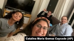 These close work friends, Catalina María Gomez Caycedo (foreground), Aleena Rupani, Henry Crabtree, and Michael Watkins meet in Crabtree's London apartment. (Photo provided by Catalina María Gomez Caycedo via AP)