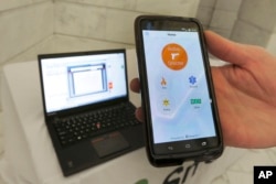 FILE - A smartphone is held during a demonstration of the Rave Panic Button application at the Arkansas state Capitol in Little Rock, Ark., Aug. 11, 2015. (AP Photo/Danny Johnston, File)