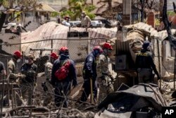 Search and rescue team members work in the area devastated by a wildfire in Lahaina, Hawaii, Aug. 17, 2023. The blazes incinerated the historic island community of Lahaina and killed more than 100 people.