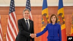 মলদোভার চিসিনাউয়ে প্রেসিডেন্ট প্রাসাদে যুক্তরাষ্ট্রের পররাষ্ট্র মন্ত্রী অ্যান্টনি ব্লিংকেন (বামে) মলদোভার প্রেসিডেন্ট মাইয়া সান্দুর (ডানে) সঙ্গে করমর্দন করছেন। ২৯ মে ২০২৪।