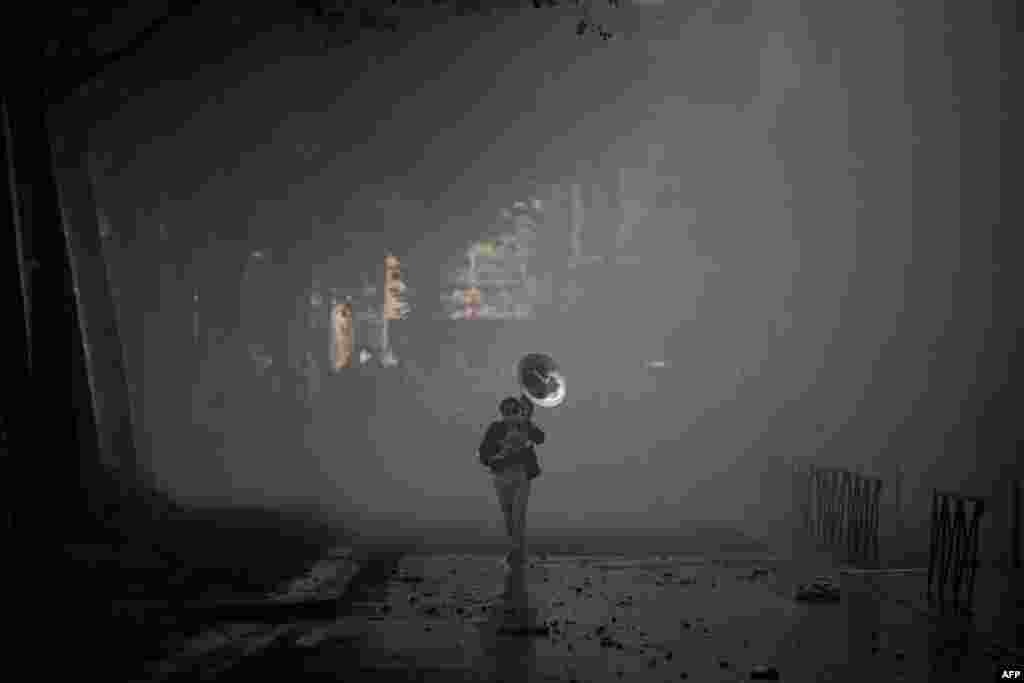 Seorang pengunjuk rasa memainkan alat musik tiup di tengah gas air mata saat pawai perayaan May Day (Hari Buruh) di Lyon, Prancis tengah-timur, 1 Mei 2024. (JEFF PACHOUD / AFP)