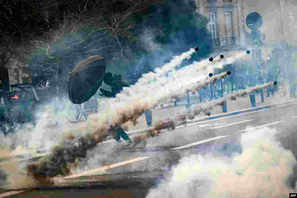 A protester holds an umbrella to protect from tear gas during a demonstration on the 8th day of strikes and protests across the country against the government&#39;s proposed pensions overhaul, in Nantes, France, March 15, 2023.