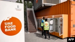 FILE - Para pekerja di Bank Makanan UEA membuka lemari es di lokasi di Dubai, 27 Maret 2023. (Karim SAHIB / AFP)