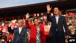FILE - Thai candidates for prime minister Paetongtarn Shinawatra (C), Srettha Thavisin (R) and Chaikasem Nitisiri (L) wave during a rally for Thailand's main opposition Pheu Thai party near Bangkok, April 5, 2023.