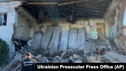 A war crimes prosecutor inspects the site of a night Russian drone attack on the near-port infrastructure in Izmail, Ukraine, Sept. 7, 2023. 