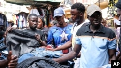 Ugandans buy used clothes at Owino Market, in Kampala, Uganda, Sept. 15, 2023. (AP Photo/Hajarah Nalwadda)