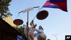 រូបឯកសារ៖ សកម្មជនសិទ្ធិមនុស្សរៀបចំតាំងជញ្ជីងយុត្តិធម៌ ក្នុងកម្មវិធីដើរហែក្បួនមួយដើម្បីអបអរសាទរខួប៧៥ឆ្នាំនៃទិវាសិទ្ធិមនុស្សអន្តរជាតិ នៅរាជធានីភ្នំពេញ កាលពីថ្ងៃទី១០ ខែធ្នូ ឆ្នាំ២០២៣។