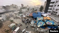 Warga Palestina memeriksa Rumah Sakit Al Shifa yang digerebek pasukan Israel selama operasi darat, di tengah gencatan senjata sementara antara Israel dan Hamas, di Kota Gaza, 25 November 2023. (Foto: REUTERS/Abed Sabah)