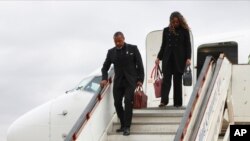 FILE - Malawi Vice President Saulos Chilima, left, and his wife, Mary, disembark from a plane upon his return from South Korea in Lillongwe, June 9, 2024. A military plane carrying Malawi's vice president and nine others went missing Monday, the president's office said. 
