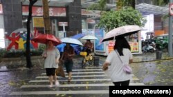 Pedestrians cross a street during a rainstorm in Shenzhen, Guangdong province, China, April 21, 2024 (cnsphoto via Reuters)