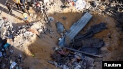 8일 가자지구 남부 라파에서 이스라엘 군의 공격으로 파괴된 주택을 주민들이 바라보고 있다.