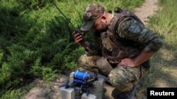 FILE - A Ukrainian serviceman prepares a first-person view (FPV) drone before flying it over positions of Russian troops, amid Russia's attacks on its neighbor, in Ukraine's Kharkiv region, May 25, 2024.