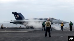 Sebuah jet tempur F-18E bersiap lepas landas dari kapal induk USS Theodore Roosevelt, Kamis 11 April 2024, selama latihan angkatan laut gabungan selama tiga hari oleh AS, Jepang, dan Korea Selatan di Laut Cina Timur. (AP/Mari Yamaguchi)