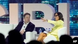 CEO Twitter Elon Musk, tengah, berbicara dengan Linda Yaccarino, ketua periklanan dan kemitraan global untuk NBC, pada konferensi di Miami Beach, Florida, 18 April 2023. (Foto: AP)