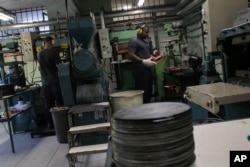 Operator sedang memproduksi piringan hitam di pabrik Polysom di Belford Roxo, Brazil, Selasa, 16 April 2024. Penjualan Vinyl di Brazil kembali berjaya, mengikuti tren global selama 15 tahun terakhir. (AP/Bruna Prado)