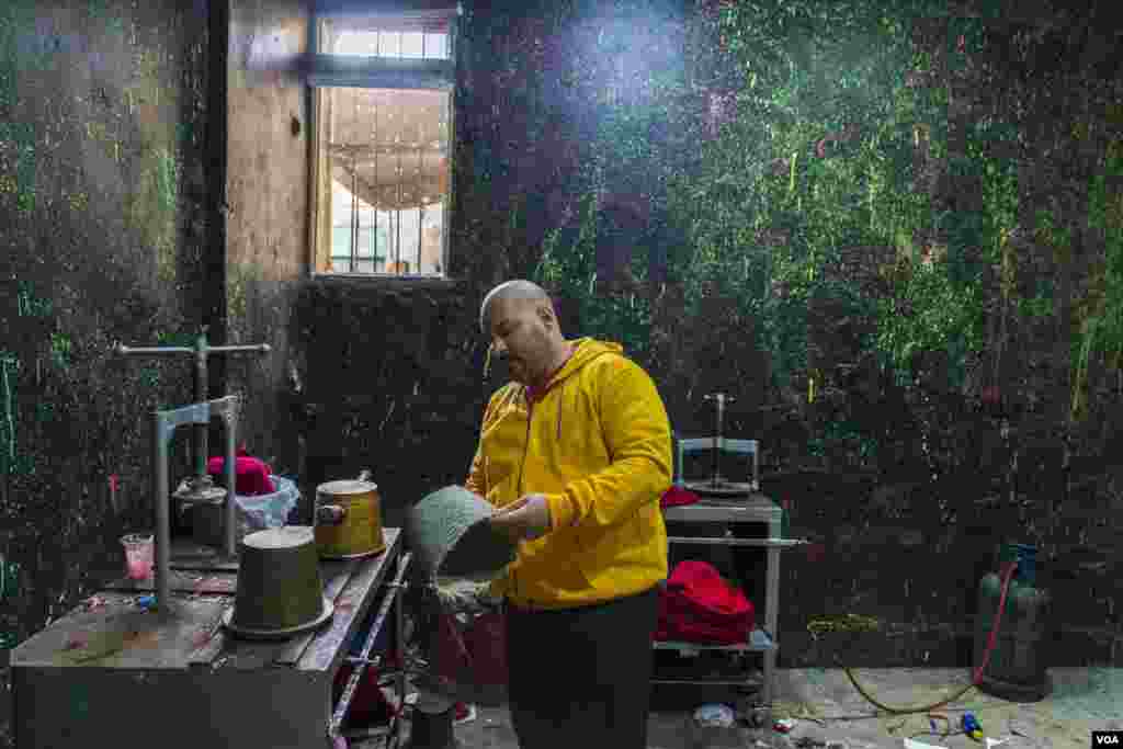 Hossam Mohamed, who designs fez hats for a living, says, “The demand for fezzes is low these days, so most of the craftspeople in this workshop have left for other jobs.” (Hamada Elrasam/VOA)