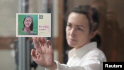 "Ozodlik” radiosi jurnalisti Alsu Kurmasheva Qozondagi sud zalida “Uni uyda kutishyapti” nomli kartani tutib turibdi, Qozon, Rossiya. 1-Aprel, 2024-yil.