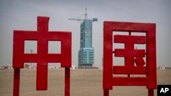 The Shenzhou-16 spacecraft sits atop a Long March rocket covered on a launch pad near characters reading "China" at the Jiuquan Satellite Launch Center in northwest China, May 29, 2023.