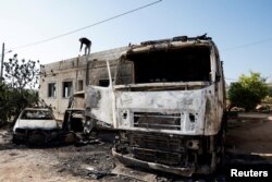 Seorang pria Palestina memeriksa kerusakan yang terjadi setelah pemukim Israel menyerang Desa al-Mughayyer, di Tepi Barat yang diduduki Israel, 13 April 2024. (Foto: REUTERS/Mohammed Torokman)