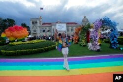 Seorang pendukung pernikahan sesama jenis memegang spanduk bertuliskan "Undang-undang kesetaraan pernikahan disahkan oleh Senat" setelah Senat Thailand menyetujui RUU penting untuk melegalkan pernikahan sesama jenis di Bangkok, Thailand, Selasa, 18 Juni 2024. (AP/Sakchai Lalit)