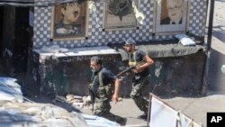 FILE - Members of the Palestinian Fatah group run to take position during a third day of clashes that erupted with Islamist factions in the Palestinian refugee camp of Ein el-Hilweh near the southern port city of Sidon, Lebanon, on July 31, 2023. 