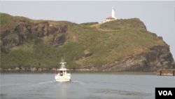 A small fishing boat pulls away from the main port on Yonaguni Island. Fisherman report seeing many more Chinese patrols in contested waters nearby. (W.Gallo/VOA)
