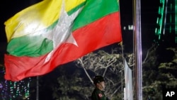 FILE - A Myanmar military soldier hoists a national flag during a ceremony to mark the 69th anniversary of Independence Day in Yangon, Myanmar on Jan. 4, 2017.