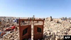 Afghan residents clear debris as they look for victims' bodies in the rubble of damaged houses after the earthquakes in Siah Ab village, Herat province, Oct. 8, 2023.