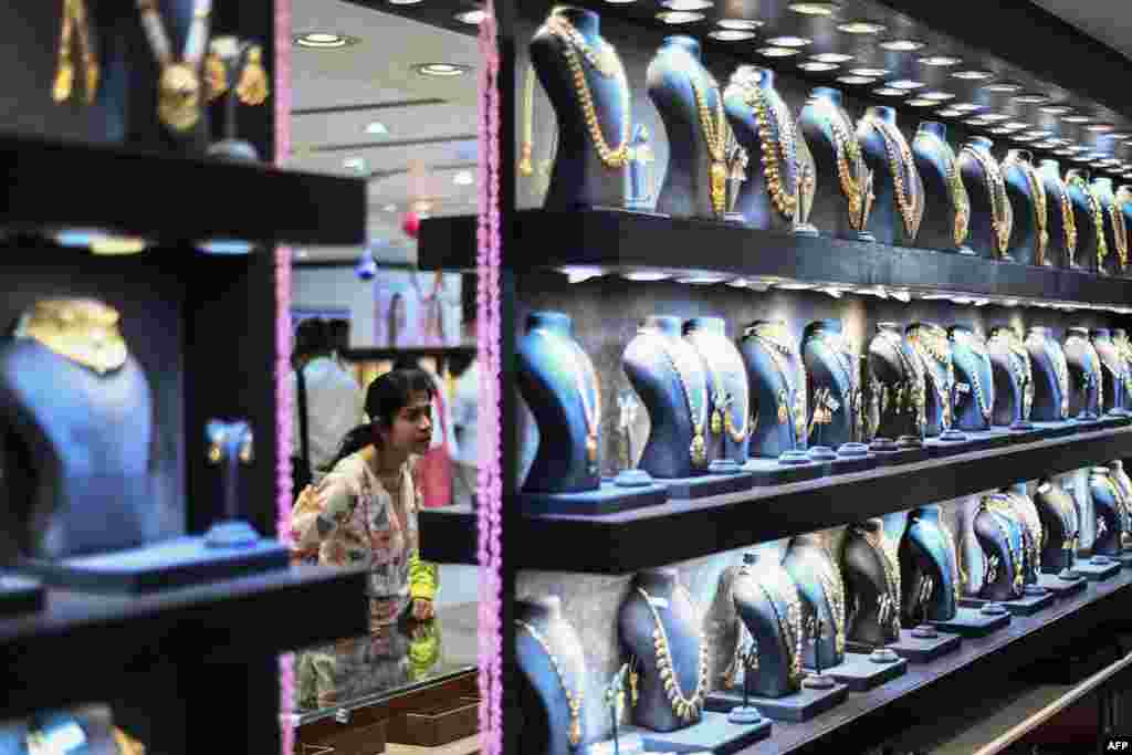 A woman buys gold jewelry during the Hindu festival of Akshaya Tritiya, considered to be an auspicious day in the Hindu calendar to buy valuables with the belief that it will increase their wealth, at a jewelry shop in Chennai.